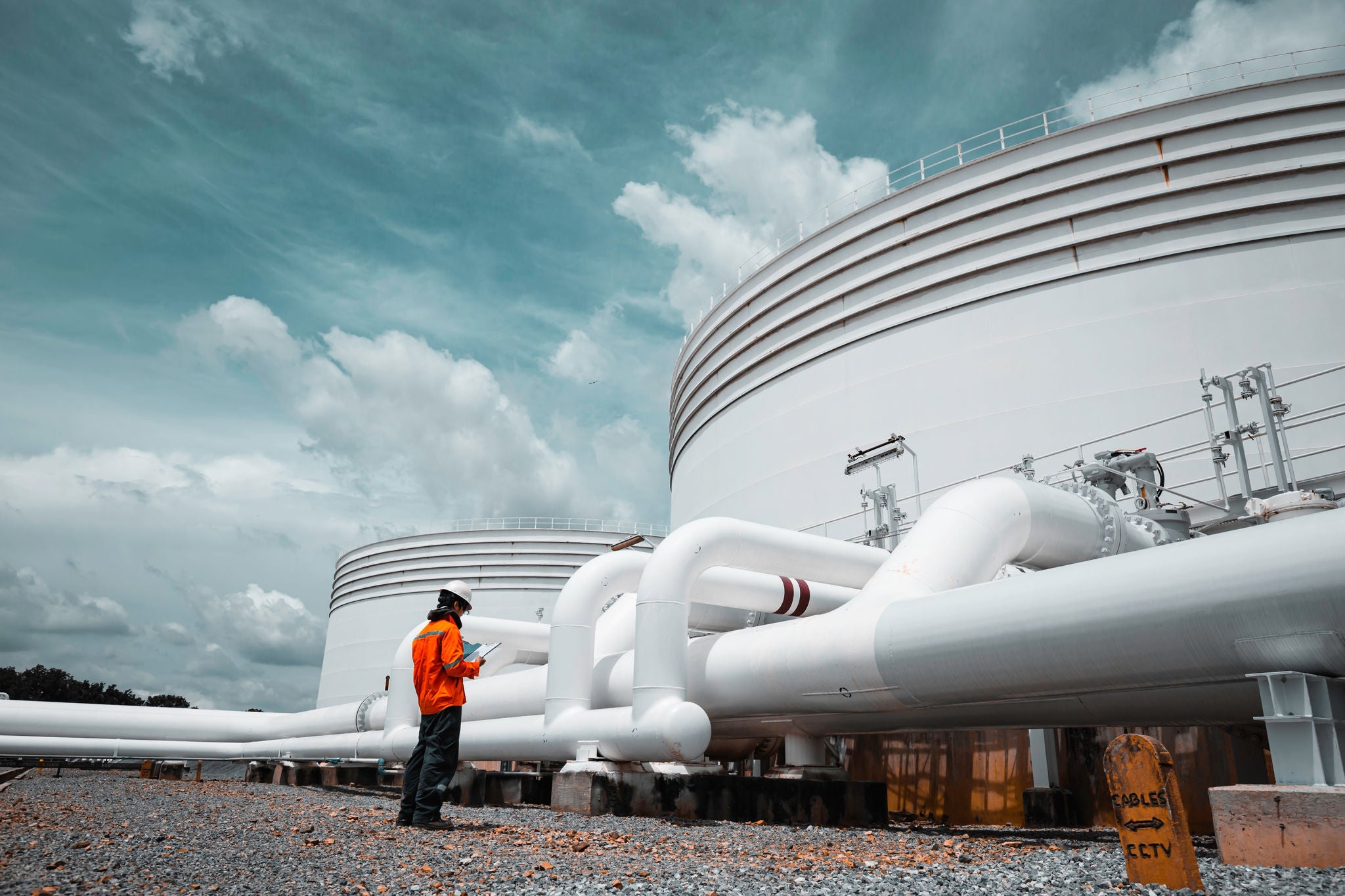 Male worker inspection at steel long pipes and pipe elbow in station oil factory during refinery valve of visual check record pipeline tank oil and gas industry