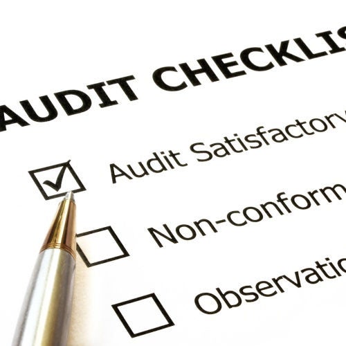 Audit checklist with silver and gold ballpoint.  Check in "audit satisfactory" box.