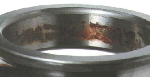 Reddish-brown fretting damage around the bore surface of a DGBB inner ring.